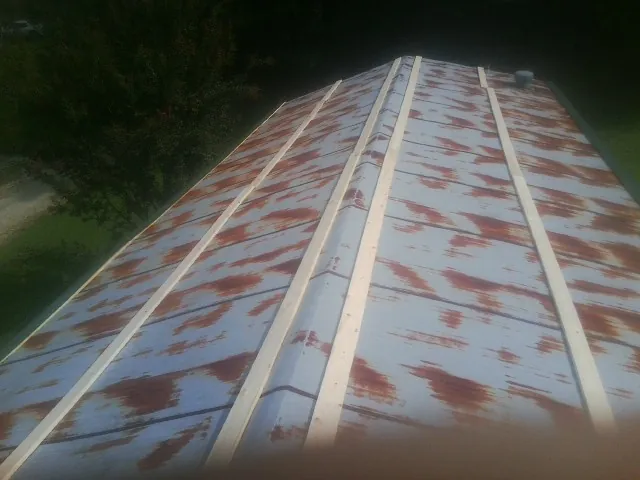 Rusted metal roof panels with new wood purlins before replacement — Storm Damage Roof Repair in Coalton by Roofing Brothers