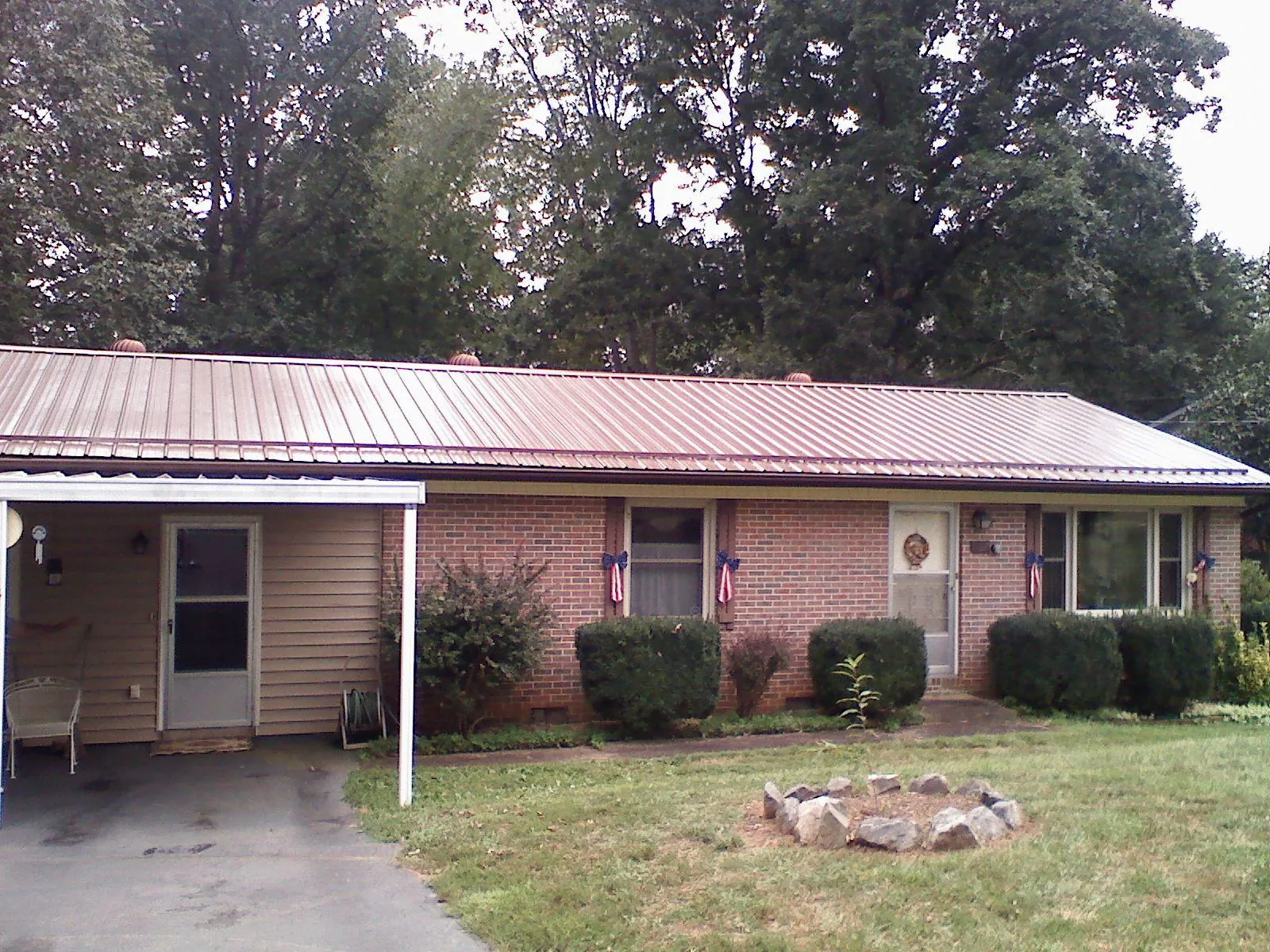 Bronze metal roof and carport on a brick ranch home — Roof Repair work by our crew in Coalton